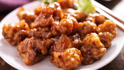 chinese orange chicken with chopsticks on round plate / Foto: Rez-art