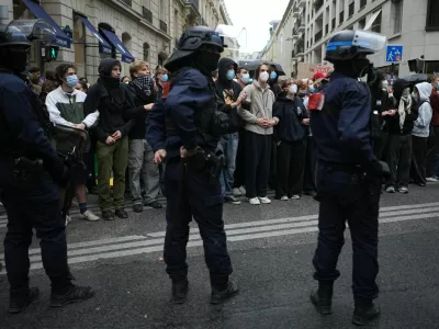 Police stand guard as students stand in front of a blockaded high school during a protest against under-resourced schools, in Paris, Wednesday, Oct. 7, 2026. (AP Photo/Thibault Camus)