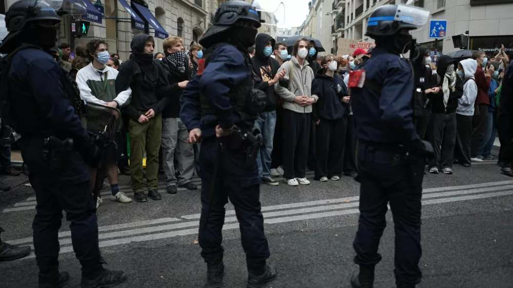 Police stand guard as students stand in front of a blockaded high school during a protest against under-resourced schools, in Paris, Wednesday, Oct. 7, 2026. (AP Photo/Thibault Camus)