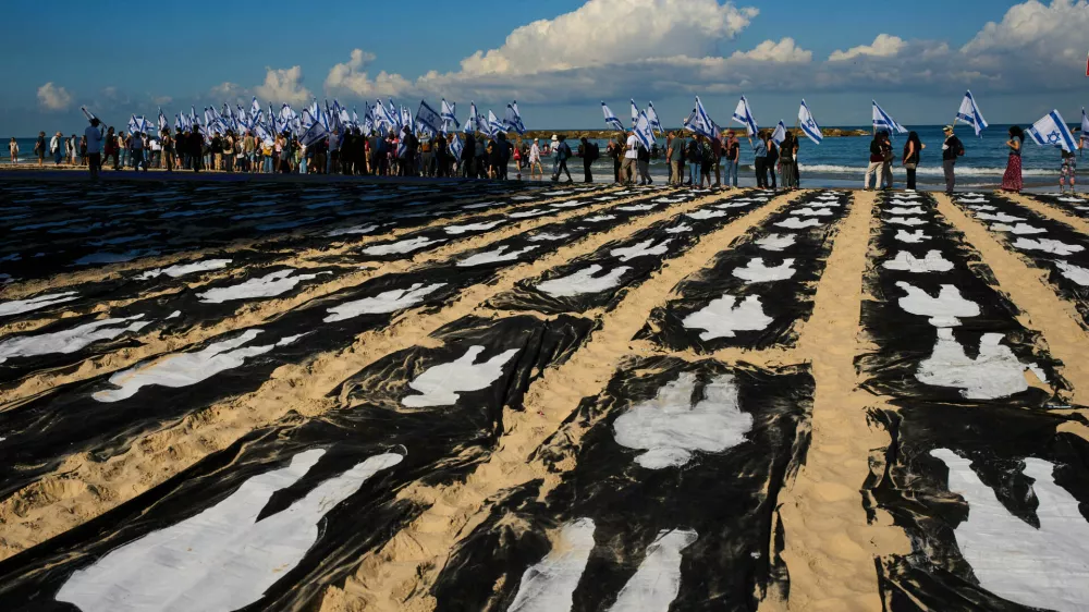 People carrying Israeli flags walk through an installation marking the third anniversary of the Oct. 7, 2023, Hamas attack on Israel, on the beachfront in Tel Aviv, Israel, Wednesday, Oct. 7, 2026. (AP Photo/Oded Balilty)