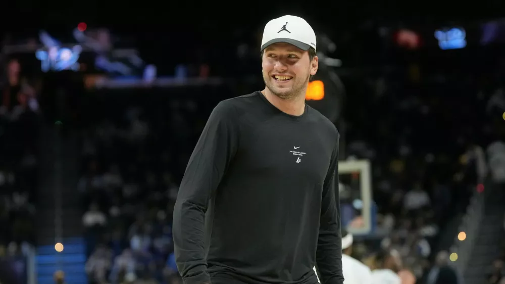 Los Angeles Lakers guard Luka Doncic smiles while walking on the floor during the second half of an NBA preseason basketball game against the Golden State Warriors, Tuesday, Oct. 6, 2026, in San Francisco. (AP Photo/Jeff Chiu)