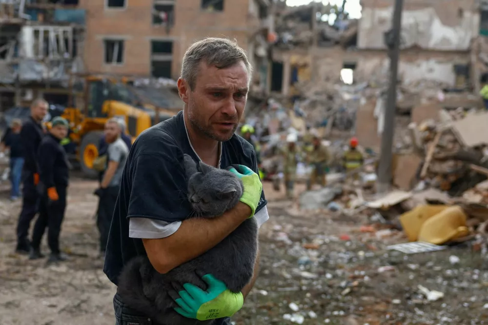 A volunteer carries a cat found at the site of an apartment building which was hit by a Russian missile strike in the town of Pryluky, amid Russia's attack on Ukraine, in the Chernihiv region, Ukraine, October 7, 2026. REUTERS/Valentyn Ogirenko   TPX IMAGES OF THE DAY
