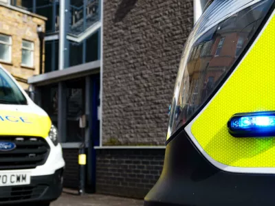 2SWK82C Metropolitan Police Service Logo / Crest on the open door of a police van alongside flashing blue light - London, England