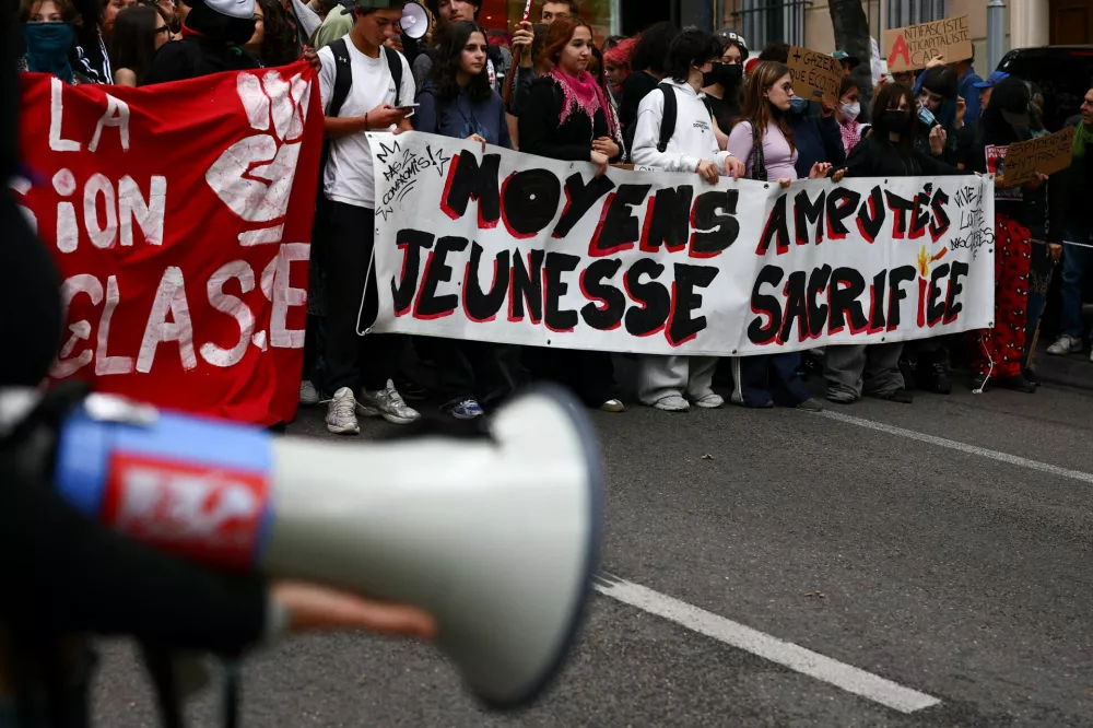 People march during a demonstration by French high school students in Marseille, as part of a nationwide day of protests and blockades, expressing anger over overcrowded classrooms, teacher shortages and dilapidated school buildings, which students blame on years of underinvestment, in Marseille, France, October 8, 2026. A banner reads: "Funding cut, youth sacrificed." REUTERS/Manon Cruz