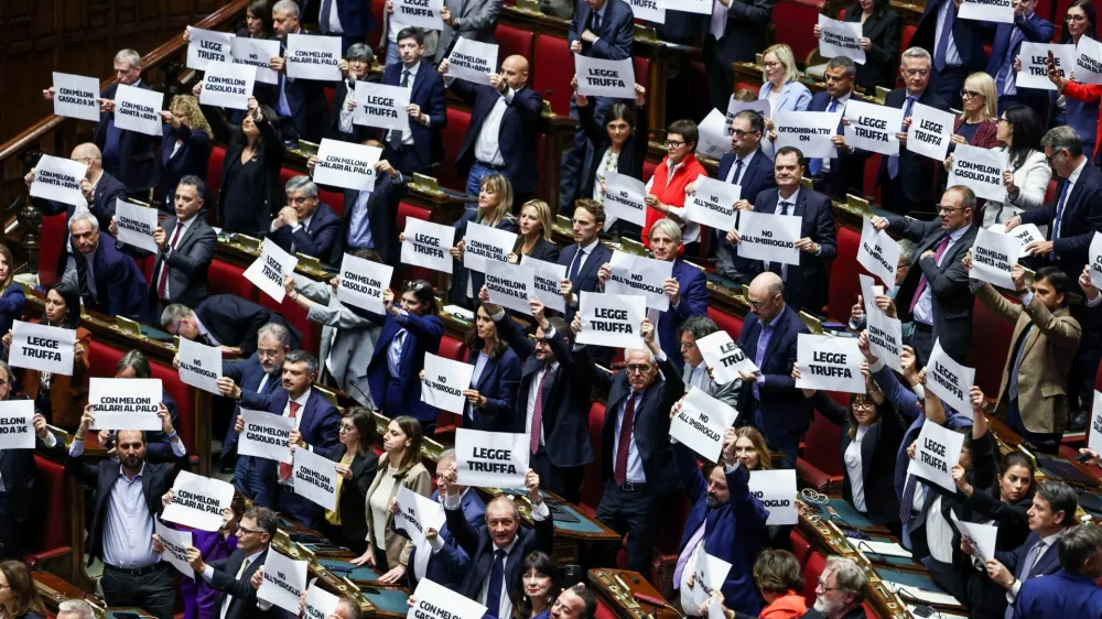 Members of parliament hold up signs at Italy's lower house of parliament on the day of a final vote on a contested electoral reform proposed by Prime Minister Giorgia Meloni, in Rome, Italy, October 8, 2026. REUTERS/Matteo Minnella   TPX IMAGES OF THE DAY