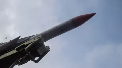 red nosed missile angled toward sky with launcher mechanism visible, closeup of seeker tip and aerodynamic