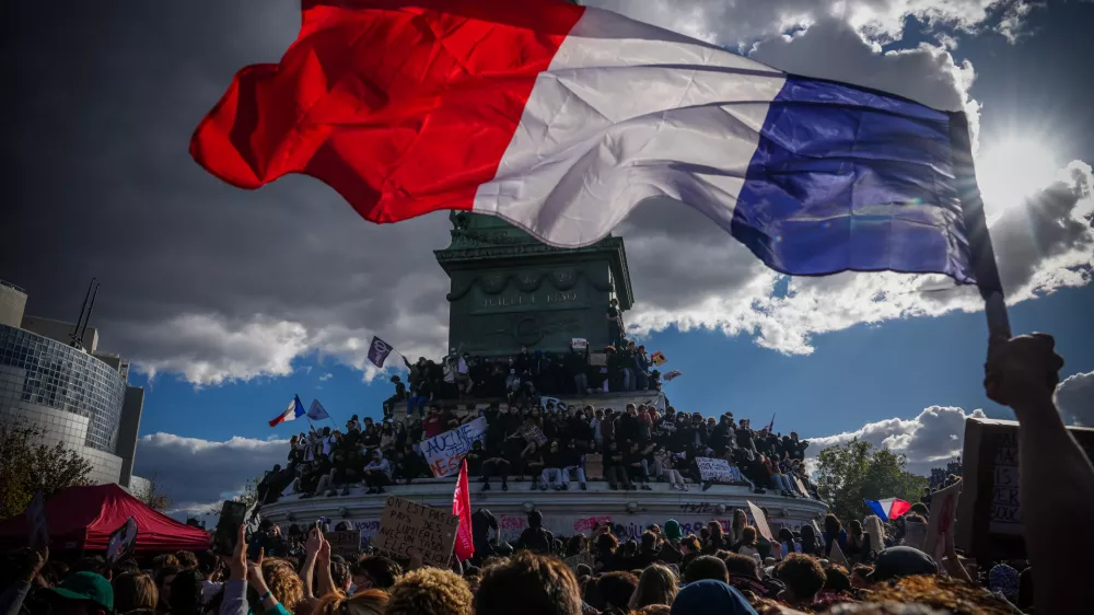 A person holds a French national flag during a protest against under-resourced schools in Paris, Thursday, Oct. 8, 2026. (AP Photo/Aurelien Morissard)