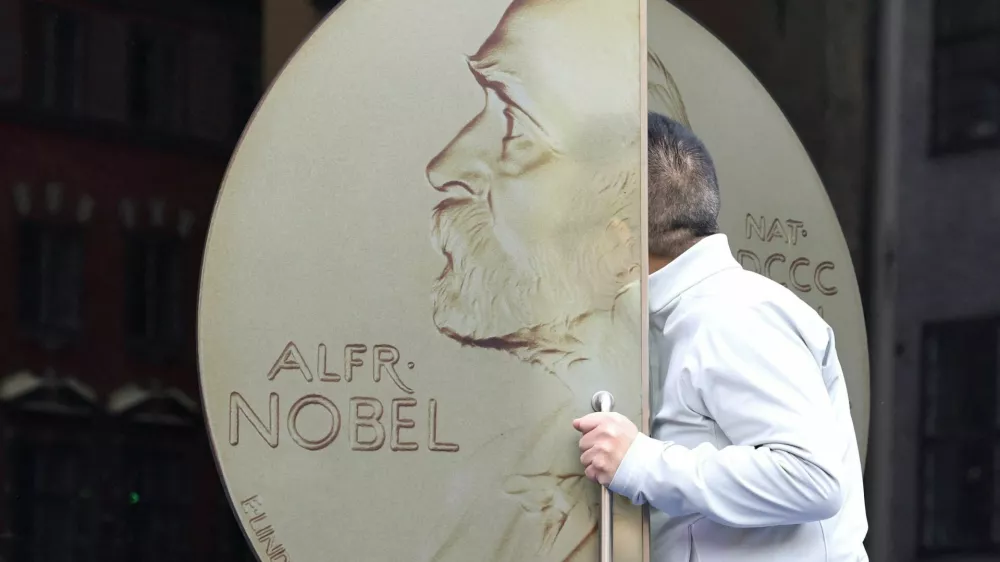 A visitor enters the Nobel Prize Museum through a door with a picture of a Nobel Prize medal on it, in a building which is also home to the Swedish Academy, in Stockholm, Sweden, October 8, 2026. REUTERS/Tom Little    TPX IMAGES OF THE DAY