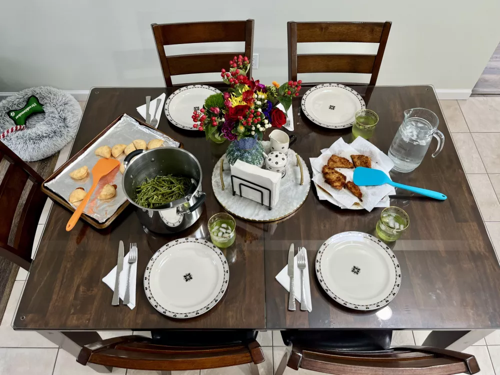 The top down view of a homemade meal consisting of fried flounder, string beans, and pizza bites.