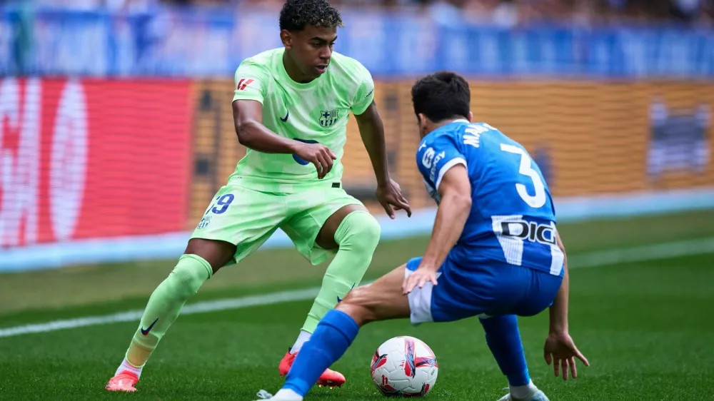 Lamine Yamal of FC Barcelona duels for the ball with Manu Sanchez of Deportivo Alaves during the LaLiga EA Sports match between Deportivo Alaves v FC Barcelona at the Estadio Mendizorrotza on October 6, 2024 in Vitoria, Spain.,Image: 1008220234, License: Rights-managed, Restrictions: Usage restrictions: Advertising and promotion,Commercial electronic,Consumer goods,Direct mail and brochures,Indoor display,Internal business usage,Personal use, Model Release: no 