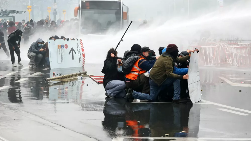 Demonstrators try to get cover from police water cannons as student protesters join a nationwide strike against the Belgian government's austerity measures and budget cuts, in Brussels, Belgium, October 9, 2026. REUTERS/Yves Herman