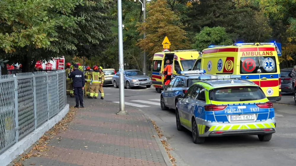 Emergency personnel stand next to vehicles outside a school, following a stabbing attack injuring several, in Ostroleka, Poland, October 7, 2026, in this picture obtained from social media. Moja Ostroleka/via REUTERS THIS IMAGE HAS BEEN SUPPLIED BY A THIRD PARTY. MANDATORY CREDIT.  VERIFICATION: - The location was verified from the fence, road layout, trees and building, which matched satellite and archive imagery. - The date when the videos were filmed was verified by original metadata and a statement from Polish police that seven people were injured in a knife attack at a school in Ostroleka.