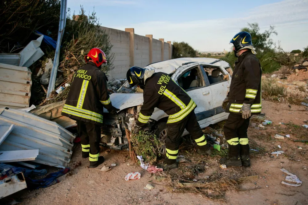 Firefighters examine a damaged car among debris after a tornado struck Petrosino, Sicily, Italy, October 9, 2026. REUTERS/Antonio Cascio