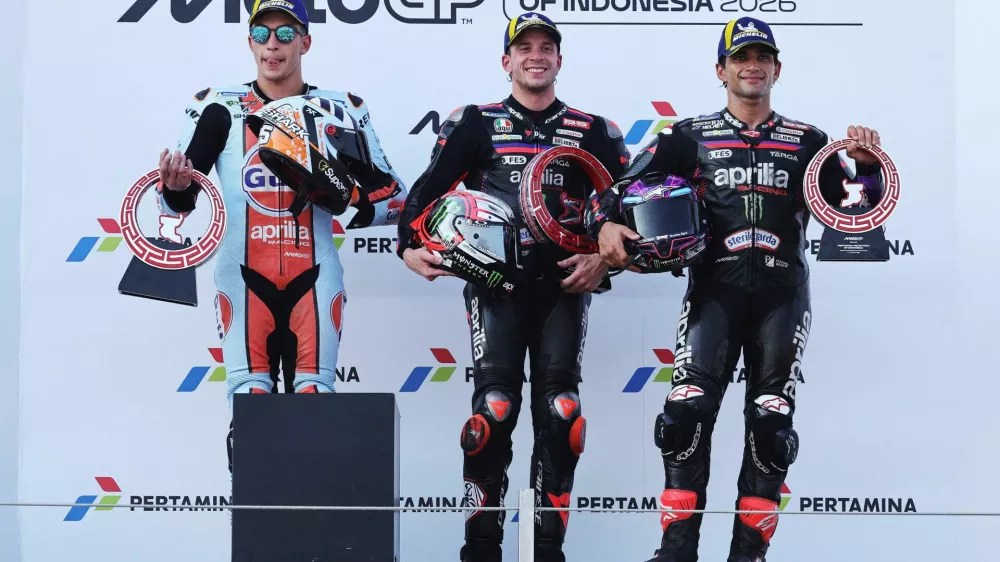 MotoGP - Indonesian Grand Prix - Mandalika International Street Circuit, Mandalika, Indonesia - October 11, 2026 Aprilia Racing's Marco Bezzecchi celebrates on the podium with a trophy after winning the MotoGP race with second place Trackhouse MotoGP Team's Raul Fernandez and third place Aprilia Racing's Jorge Martin REUTERS/Willy Kurniawan   TPX IMAGES OF THE DAY