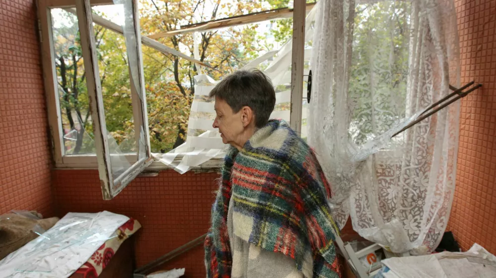 A woman stands inside her apartment in a residential building that was hit by a Russian drone strike, amid Russia's attack on Ukraine, in Dnipro, Ukraine, October 11, 2026. REUTERS/Stringer