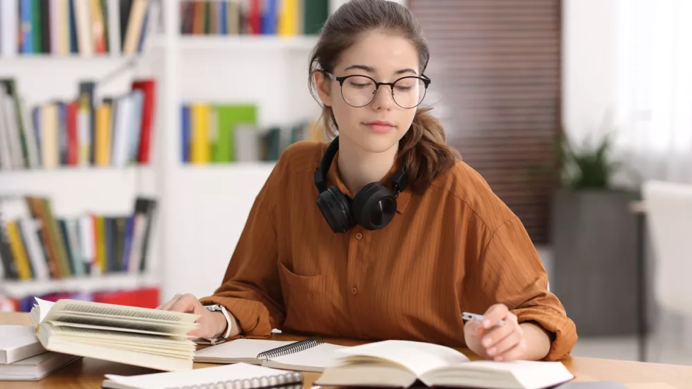 Student preparing for exam at table indoors