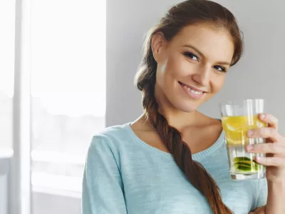 Healthy Lifestyle, Food. Happy Woman Drinking Summer Refreshing Fruit Flavored Infused Water With Fresh Organic Lemon, Lime, Mint. Detox Vitamin-fortified Water. Healthy Eating. Vitamin, Diet Concept.