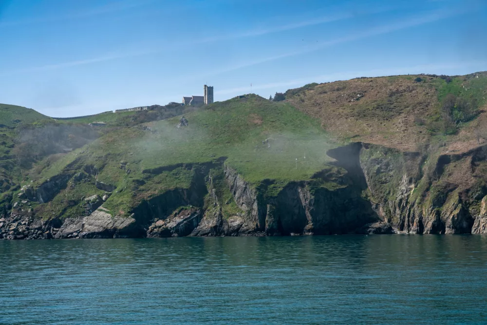 Sea mist or fog shrouds the cliffs of Lundy Island off the coast of Devon