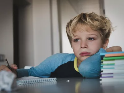 little boy tired exhausted stressed of reading, doing homework