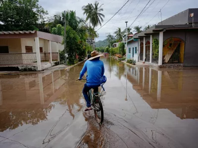 A person rides a bicycle through a flooded street as Hurricane Simon remains off Mexico's Pacific coast, in San Francisco, Bahia de Banderas, Nayarit state, Mexico, October 12, 2026. REUTERS/Christian Ruano   TPX IMAGES OF THE DAY