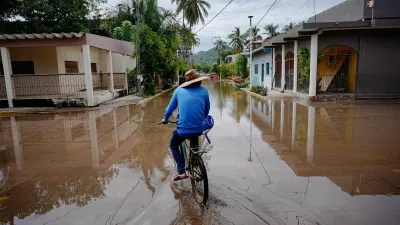 A person rides a bicycle through a flooded street as Hurricane Simon remains off Mexico's Pacific coast, in San Francisco, Bahia de Banderas, Nayarit state, Mexico, October 12, 2026. REUTERS/Christian Ruano   TPX IMAGES OF THE DAY