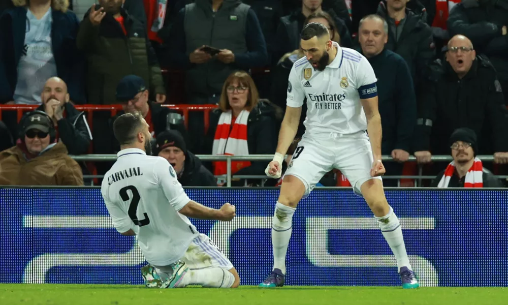 Soccer Football - Champions League - Round of 16 First Leg - Liverpool v Real Madrid - Anfield, Liverpool, Britain - February 21, 2023 Real Madrid's Karim Benzema celebrates scoring their fourth goal with Dani Carvajal REUTERS/Phil Noble