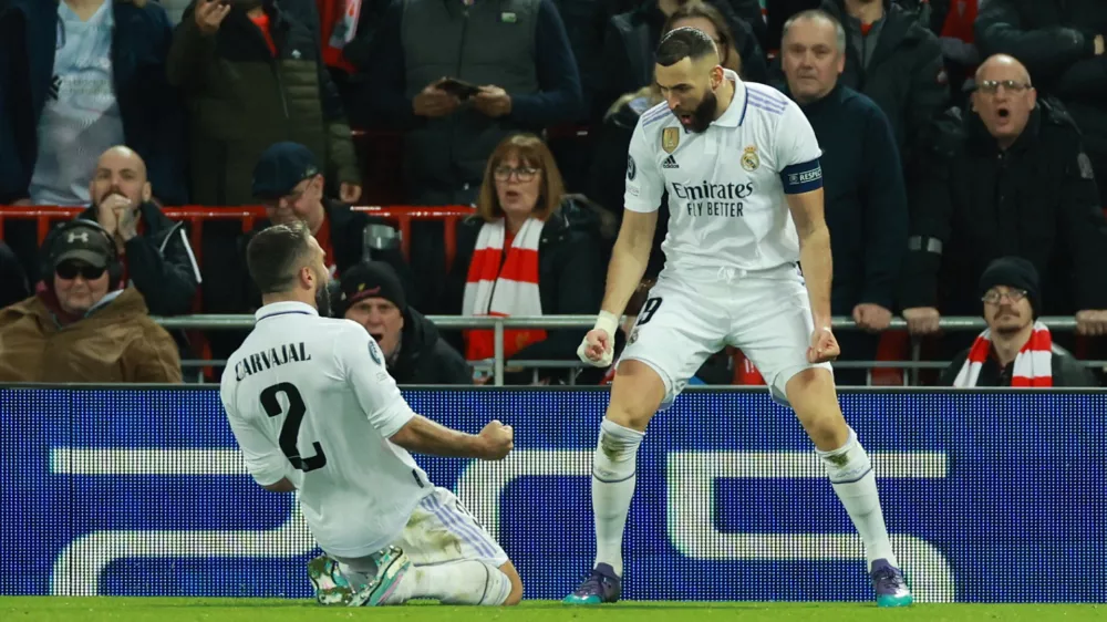 Soccer Football - Champions League - Round of 16 First Leg - Liverpool v Real Madrid - Anfield, Liverpool, Britain - February 21, 2023 Real Madrid's Karim Benzema celebrates scoring their fourth goal with Dani Carvajal REUTERS/Phil Noble
