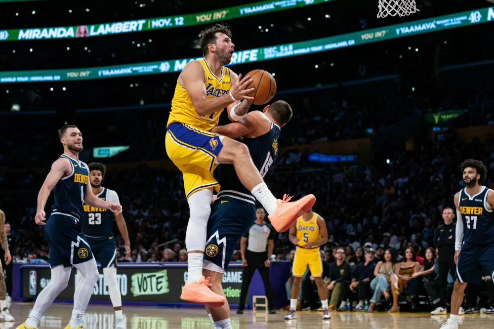 Oct 16, 2026; Los Angeles, California, USA; Los Angeles Lakers guard Luka Doncic (77) is fouled and scores against Denver Nuggets center Nikola Jokic (15) in the second quarter at Crypto.com Arena. Mandatory Credit: Jon Endow-Imagn Images / Foto: Jon Endow