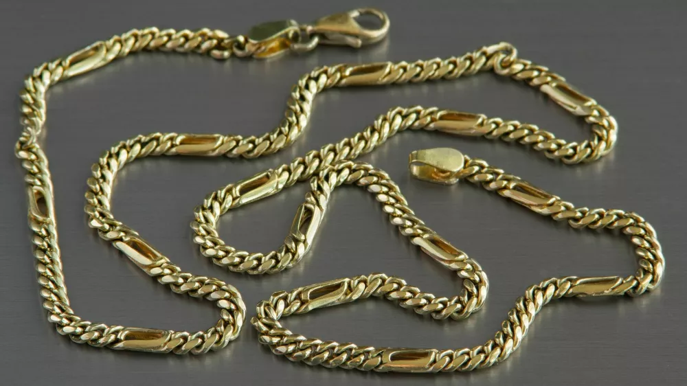 Gold chain on the aluminium background / Foto: A_pobedimskiy
