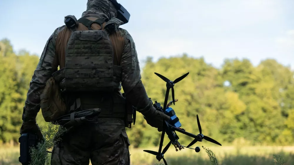 vojak v rokah drži dron