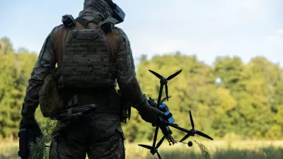 vojak v rokah drži dron