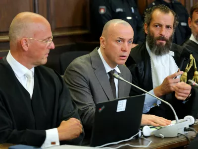 Serhii Kusnetzow, a former Ukrainian army officer charged by German federal prosecutors with being a co-perpetrator of a war crime over the 2022 Nord Stream gas pipeline blasts, sits between his lawyers as he attends his trial in Hamburg, Germany, October 14, 2026. Markus Scholz/Pool via REUTERS REFILE &ndash; FULL NAME ADDED FOLLOWING THE LIFTING OF THE COURT'S ANONYMISATION ORDER.