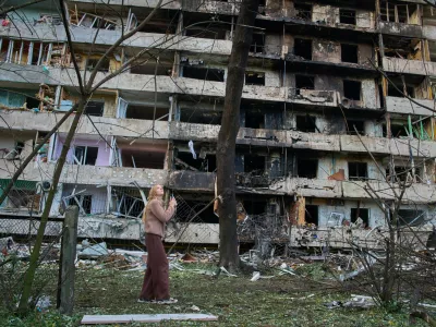 A young woman reacts as she looks at her damaged home after Russia's night missile attack in Kyiv, Ukraine, Wednesday, Oct. 14, 2026. (AP Photo/Efrem Lukatsky)