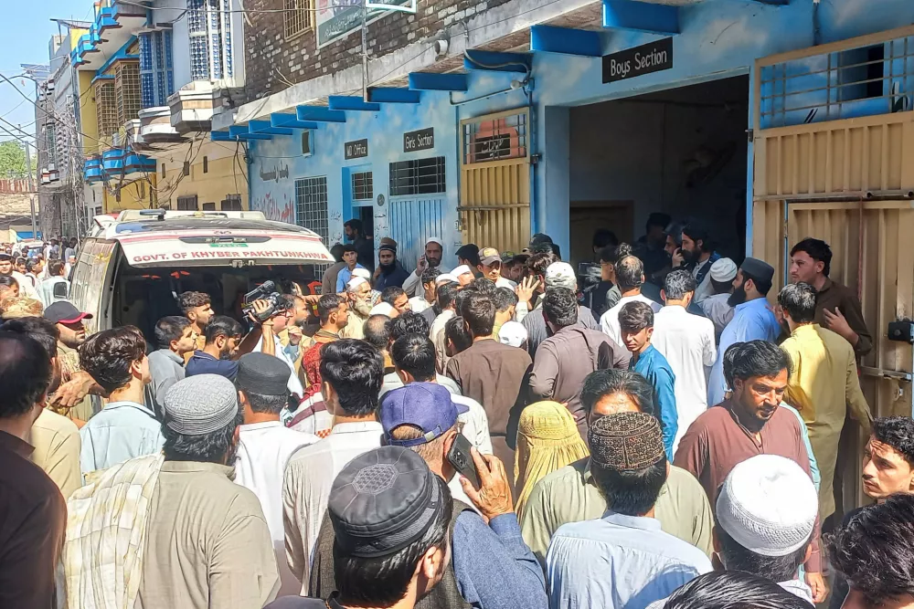 Residents and rescue workers gather near an ambulance after a school roof collapse in Peshawar Pakistan, October 15, 2026. Picture taken with a mobile phone. REUTERS
