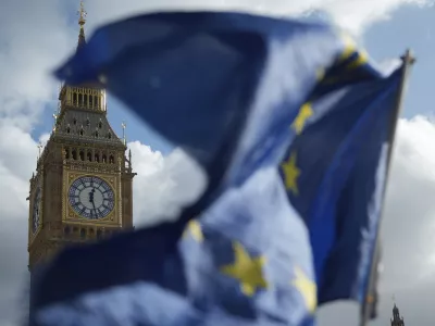 Pro EU supporters wave EU flags outside The Houses of Parliament in London, Wednesday, Oct. 14, 2026. (AP Photo/Alastair Grant)