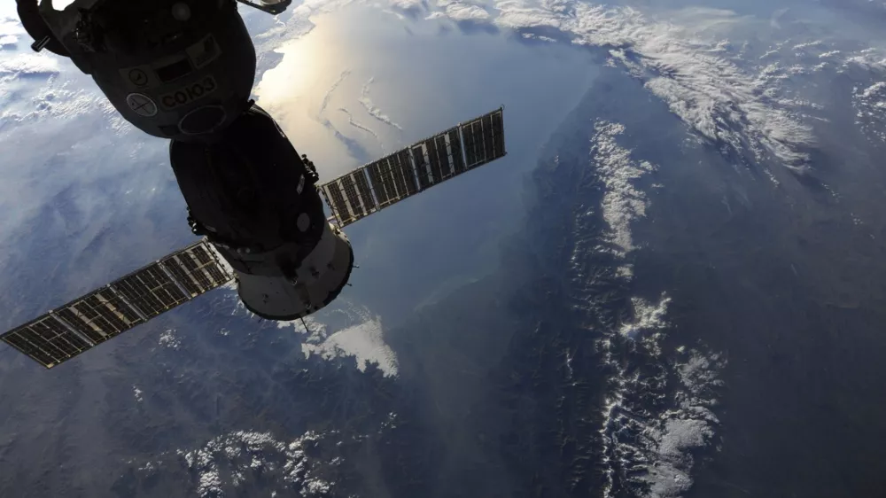 In this image provided by NASA shows the view out of the Cupola window shows the Soyuz 23S, "Olympus" module docked to the nadir side of the International Space Station taken by astronaut Douglas Wheelock as the space station was passing over the majestic snow-capped Caucuses. The sun rising and reflecting off the Caspian Sea. (AP Photo/NASA - Douglas Wheelock)