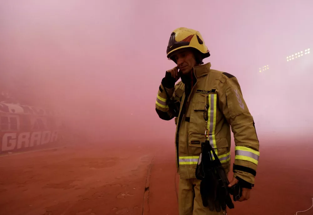 Soccer Football - UEFA Conference League - Hajduk Split v Ajax Amsterdam - Poljud Stadium, Split, Croatia - October 15, 2026 A firefighter stands pitch side as smoke from flares is seen during the match REUTERS/Miroslav Lelas