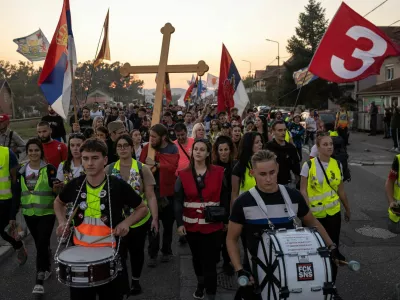 Students from Gornji Milanovac walk along a road with flags and drums during their walk to Belgrade in the town of Lajkovac, Serbia, October 19, 2026. REUTERS/Marko Djurica