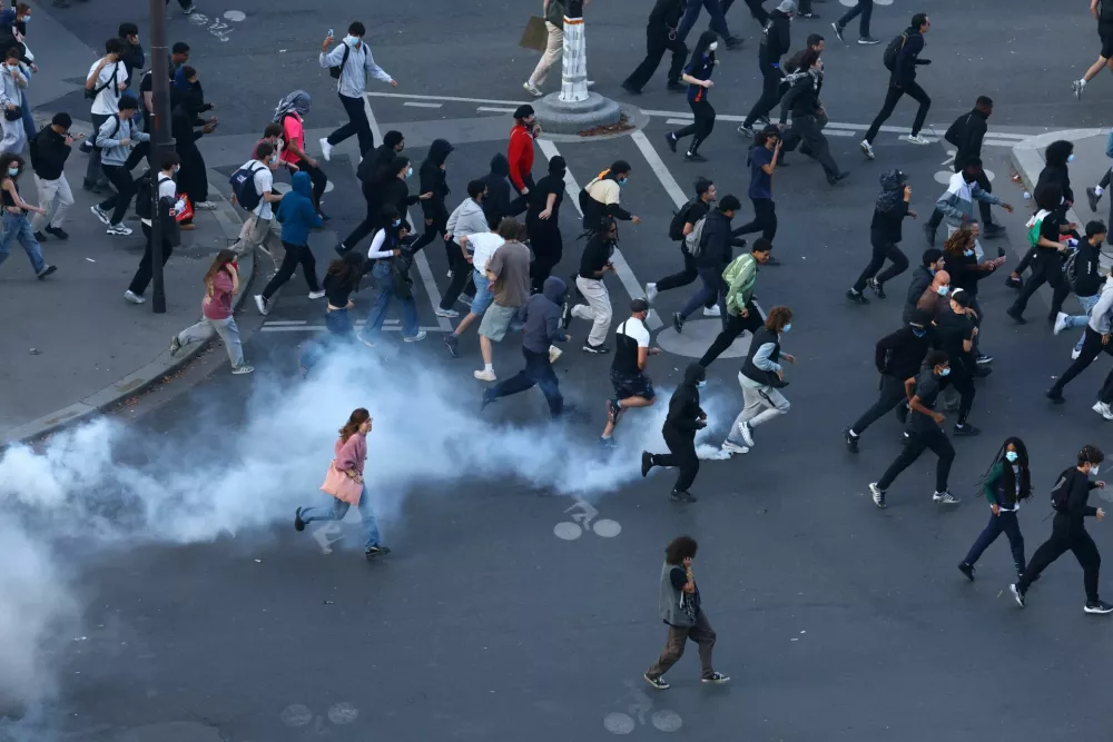 Protesters run through tear gas amid clashes with French police at Place de la Nation during a demonstration by high school and university students, supported by teachers' union and school parents, in Paris as part of a nationwide day of demonstrations and blockades, voicing anger over overcrowded classrooms, teacher shortages and dilapidated school buildings, which students blame on years of underinvestment, France, October 6, 2026. REUTERS/Yves Herman