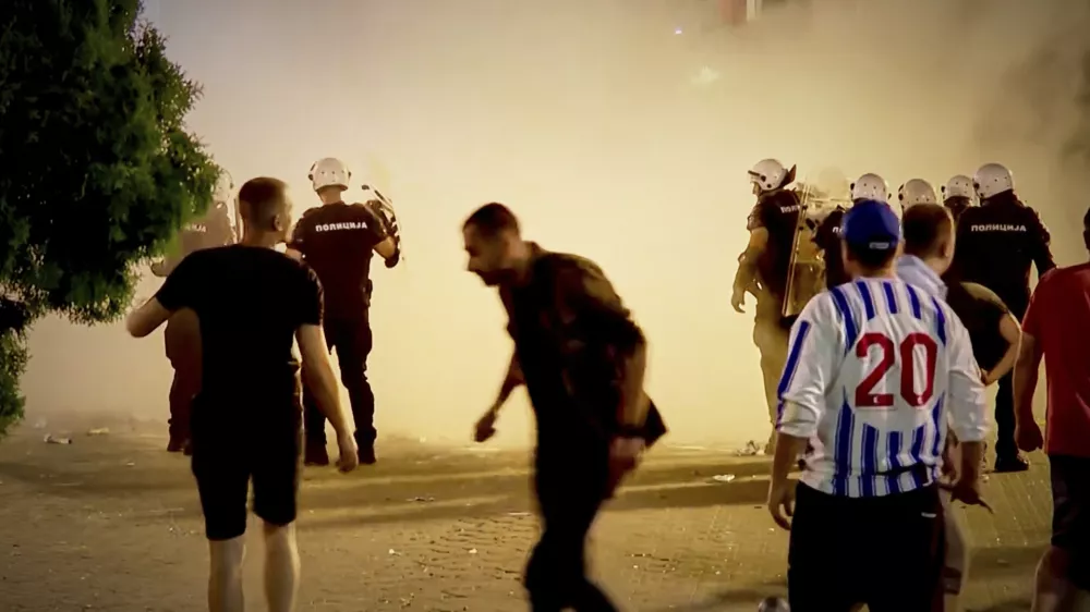 An image taken from video shows protesters and riot police engulfed by smoke as clashes erupted at protests in Vrbas, Serbia, Tuesday, Aug. 12, between opponents and supporters of the government in an escalation of tensions following more than nine months of persistent demonstrations against populist President Aleksandar Vucic. (N1 Serbia via AP)