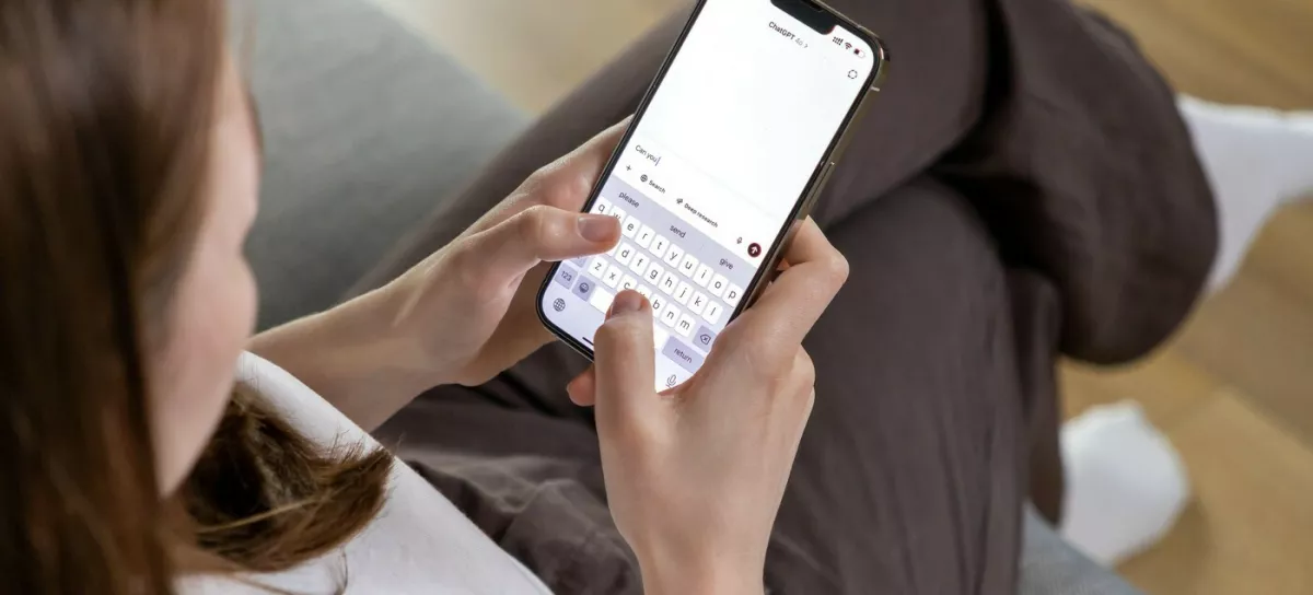 Poznan, Poland &ndash; April 14, 2025: A woman holding a smartphone and typing a question to the ChatGPT AI assistant, using a conversational text interface on the app,Image: 991604543, License: Royalty-free, Restrictions:, Model Release: no 