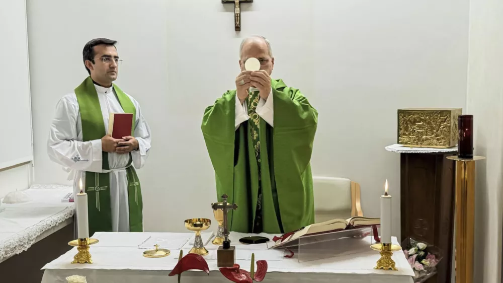 This picture released by Vatican Media on Friday, Oct. 16, 2026, shows Pope Leo XIV, flanked by his personal secretary monsignor Edgard Iv&aacute;n Rimaycuna Inga, left, celebrating Mass at the Agostino Gemelli Polyclinic in Rome where he's recovering after he had a cancer removed from his right lung. (Vatican Media via AP)