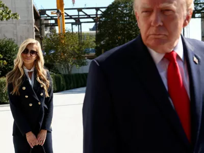 FILE PHOTO: New White House Press Secretary Katie Zacharia stands behind US President Donald Trump as he departs the White House in Washington, DC, US, October 13, 2026.  REUTERS/Kevin Lamarque/File Photo
