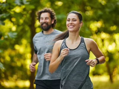 Young couple jogging in the woods, enjoying a healthy lifestyle / Foto: Stockphotodirectors