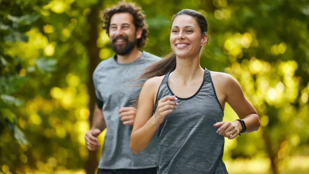 Young couple jogging in the woods, enjoying a healthy lifestyle / Foto: Stockphotodirectors