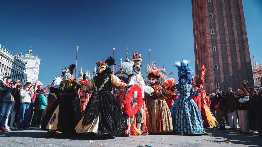 Venice, Italy - March 01, 2025: Participants in stunning costumes gather in St Marks Square, showcasing elaborate masks during the lively Venice carnival festivities. / Foto: Dave Primov