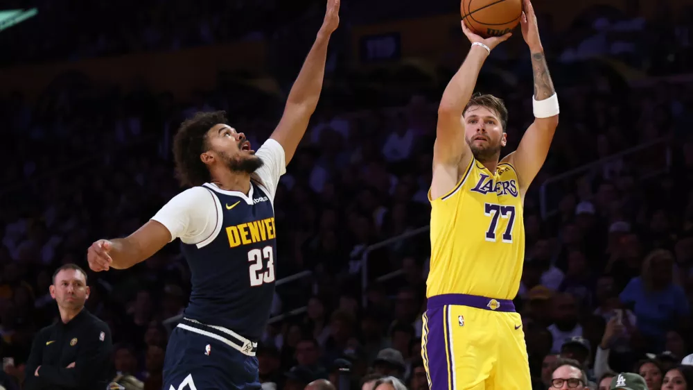 Los Angeles Lakers guard Luka Doncic (77) shoots over Denver Nuggets forward Cameron Johnson (23) during the first half of a preseason NBA basketball game Friday, Oct. 16, 2026, in Los Angeles. (AP Photo/Ben Liebenberg)