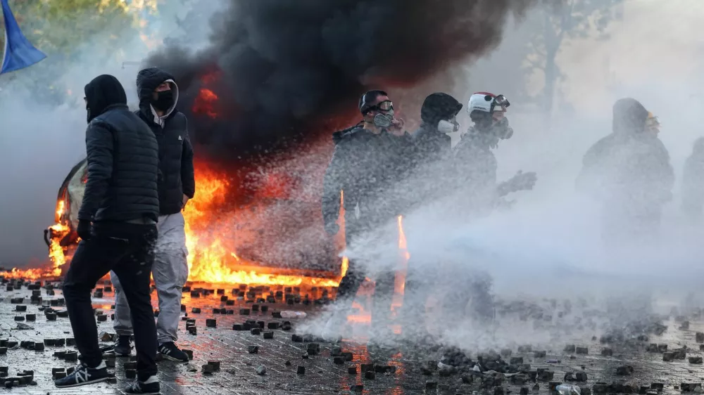 Protesters gather near a burning vehicle as a water cannon tries to spray them during an anti-government protest by students in Tirana, Albania, October 17, 2026. REUTERS/Louisa Gouliamaki