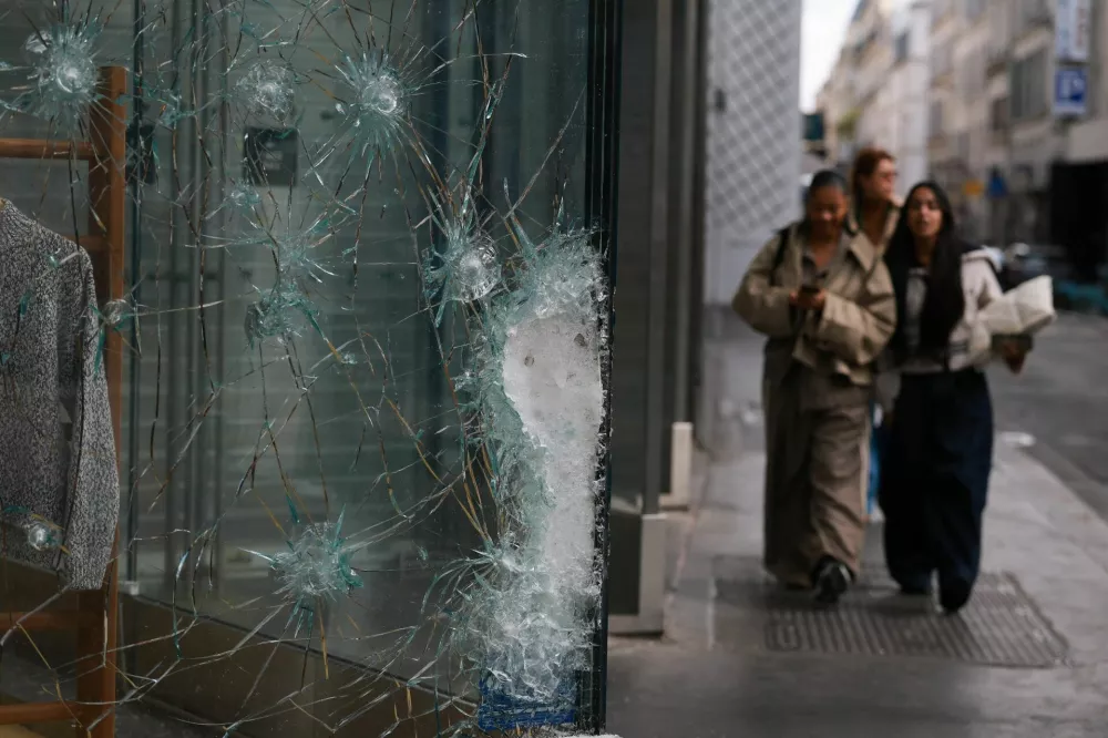 Damaged glass at the Lacoste store on Champs-Elysees avenue, the day after clashes during a national day of demonstrations against the cost of living and rising fuel prices, in Paris, France, October 18, 2026. REUTERS/Stephanie Lecocq