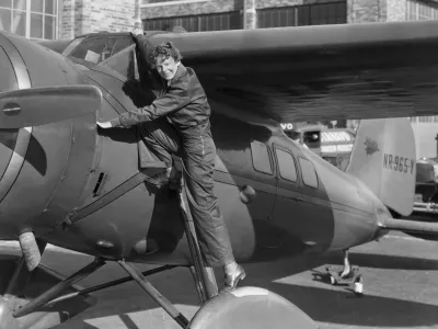 (Original Caption) Amelia Earhart, (1898-1937), first woman to cross the Atlantic Ocean in an airplane. She is shown climbing into the cockpit. Undated photograph.